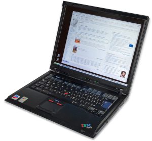A tablet and laptop sit side by side on a tidy study desk with notebooks.